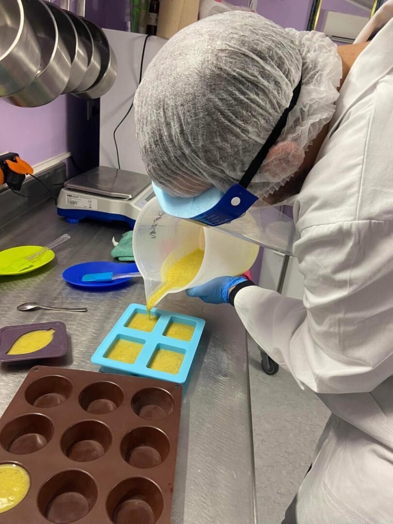 Participante coulant son savon dans des moules en silicone